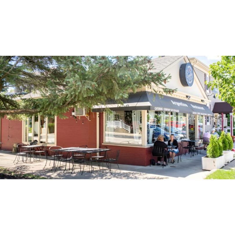 Bendita Cocina Argentinean Restaurant exterior with outdoor seating, red building, and black awning.